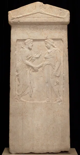 Stele funeraria greca raffigurante una coppia che si saluta, prendendosi affettuosamente per mano. Questa stele funeraria proviene dal Kerameikos di Atene ed è datata al V secolo a.C. È ora conservata presso il Minneapolis Institute of Art.